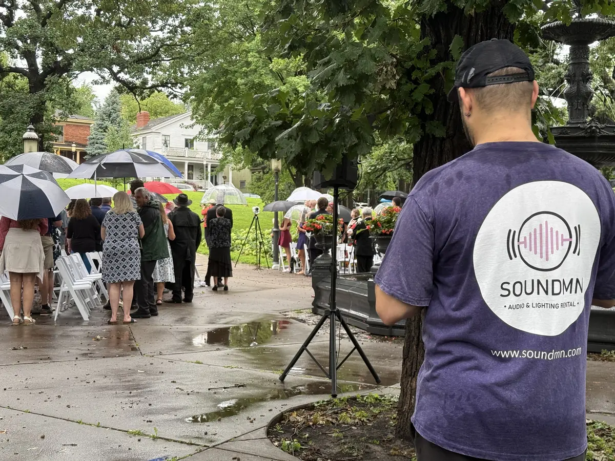SoundMN technician working during rain at an outdoor wedding ceremony, ensuring sound equipment stays protected and operational