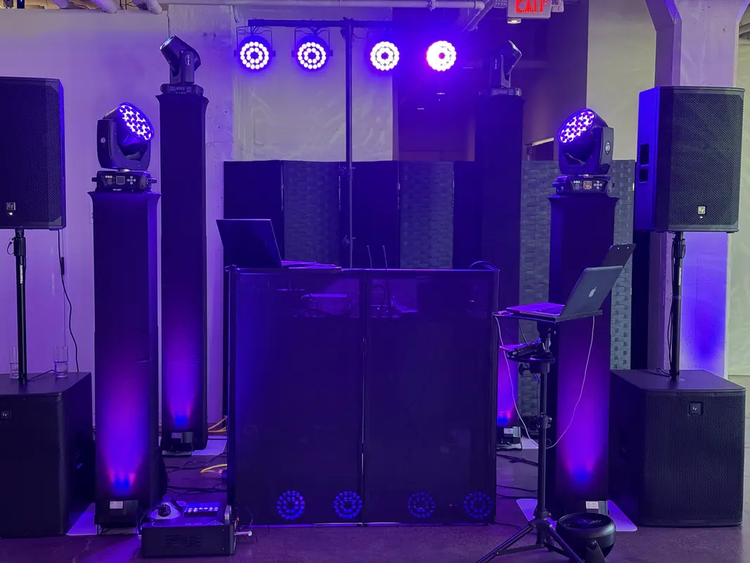 Full DJ booth with moving head lights, speakers, and subwoofers