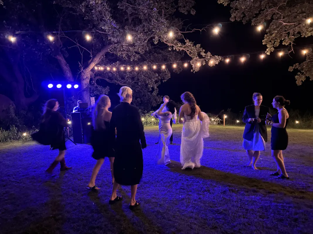 Outdoor wedding at night with string lights and blue uplighting