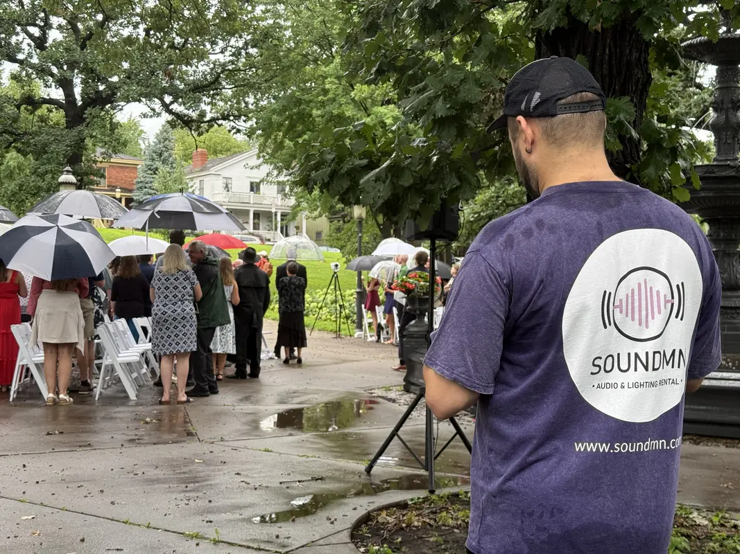 SoundMN team member in branded shirt delivering equipment in the rain