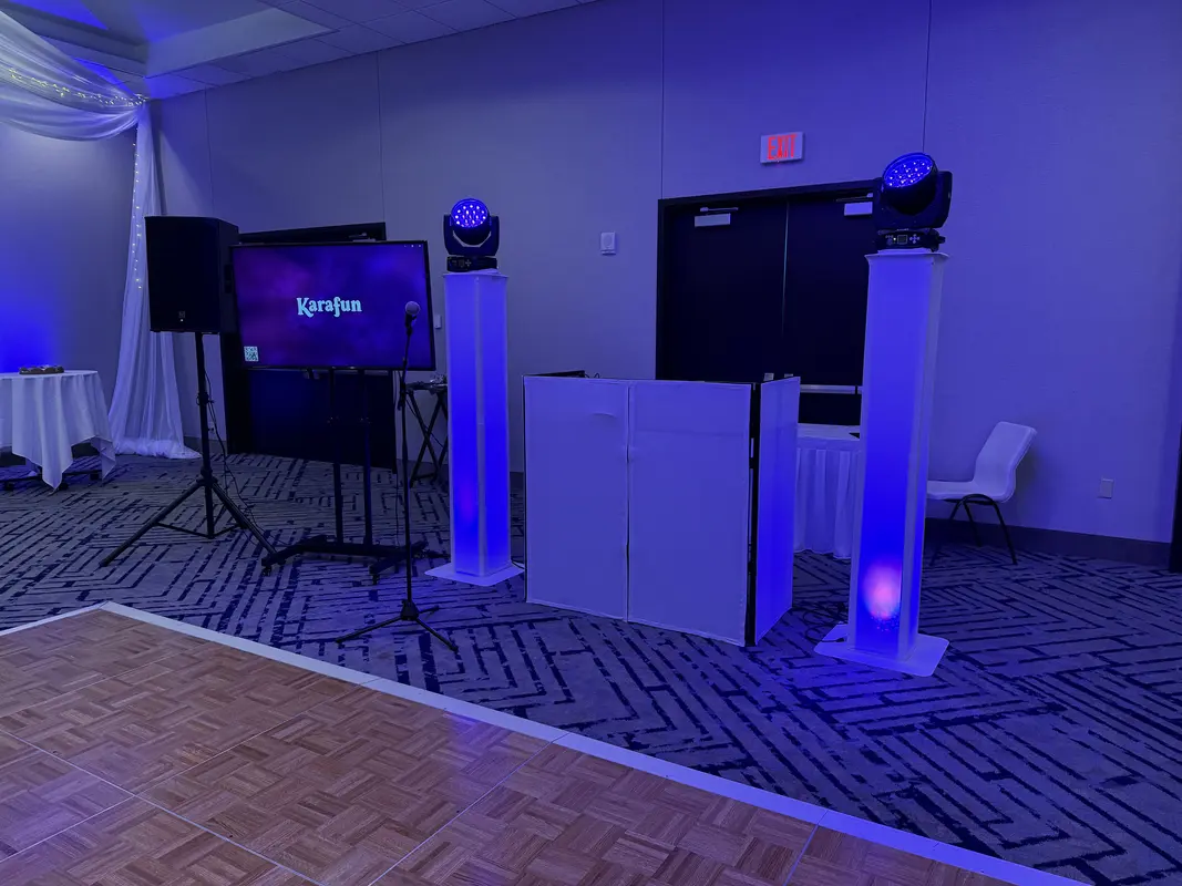 Wedding reception setup with speakers and LED uplighting pillars