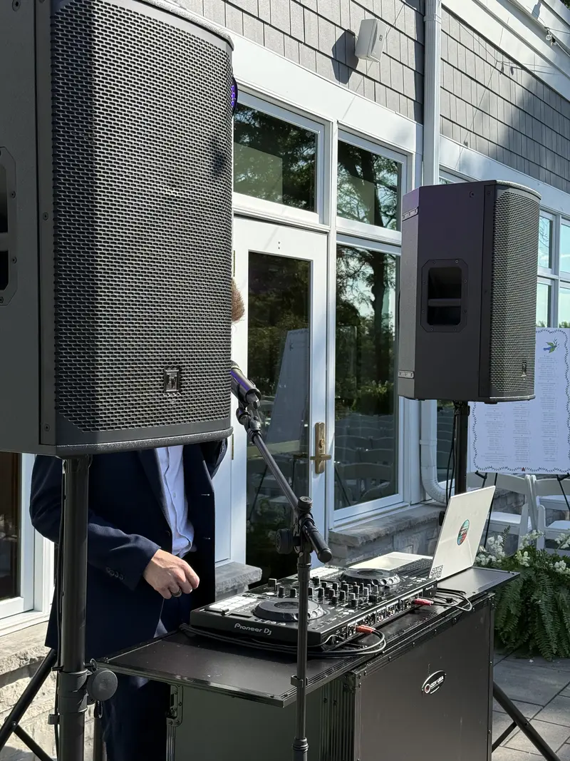 Outdoor wedding reception with string lights and sound system at night