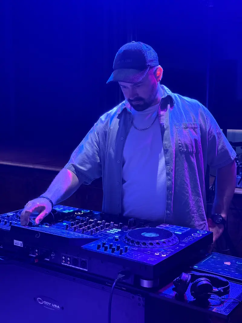 Professional DJ mixing at a corporate event with blue lighting