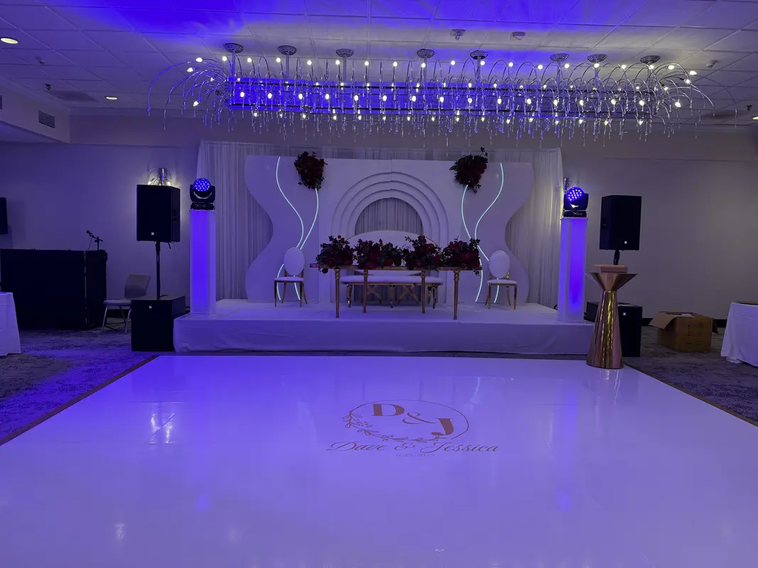 Elegant wedding reception with speakers, uplighting, and white dance floor