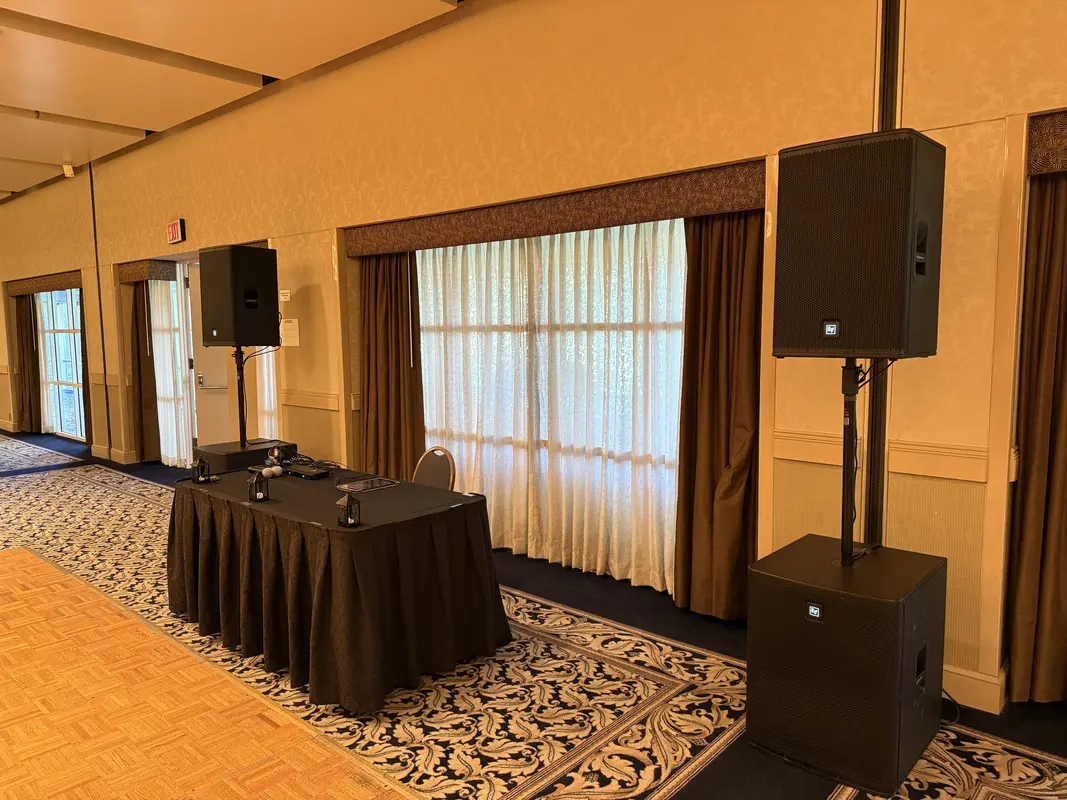 Elegant wedding dinner table with speaker and purple uplighting
