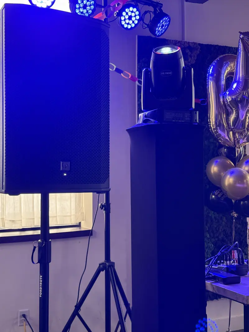 Birthday party speaker setup with balloons and decorations