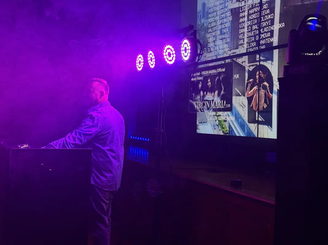 DJ setting up equipment at a bar venue with moving head lights