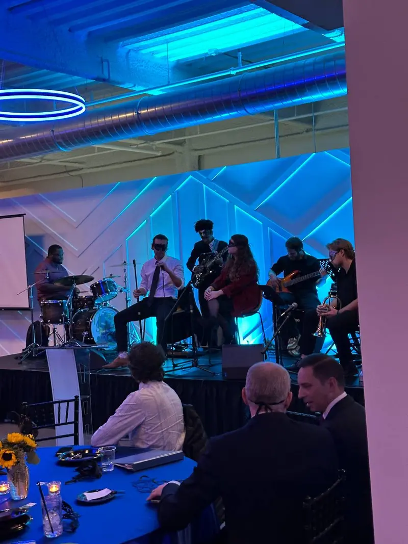 Live band performing at a corporate gala with blue event lighting