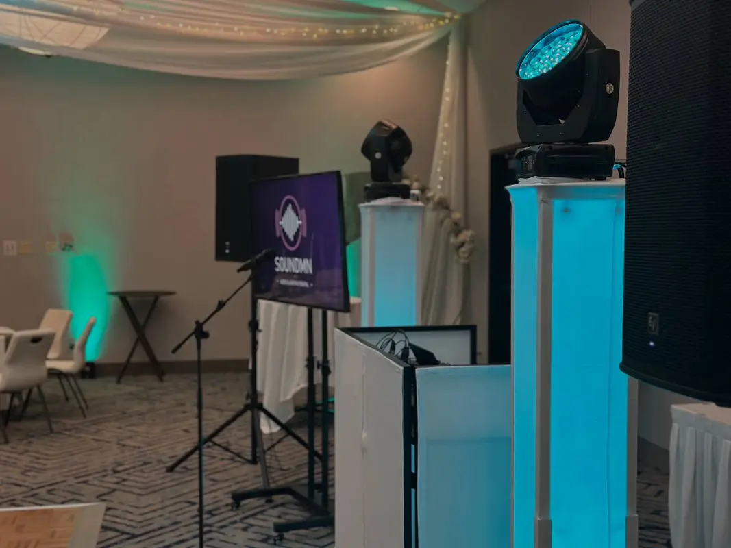 DJ booth with LED pillars and moving heads at a wedding reception