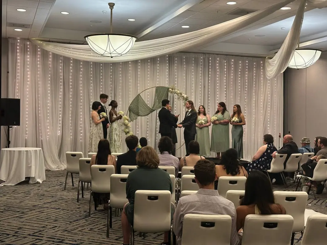 Indoor wedding ceremony with string light backdrop and sound system